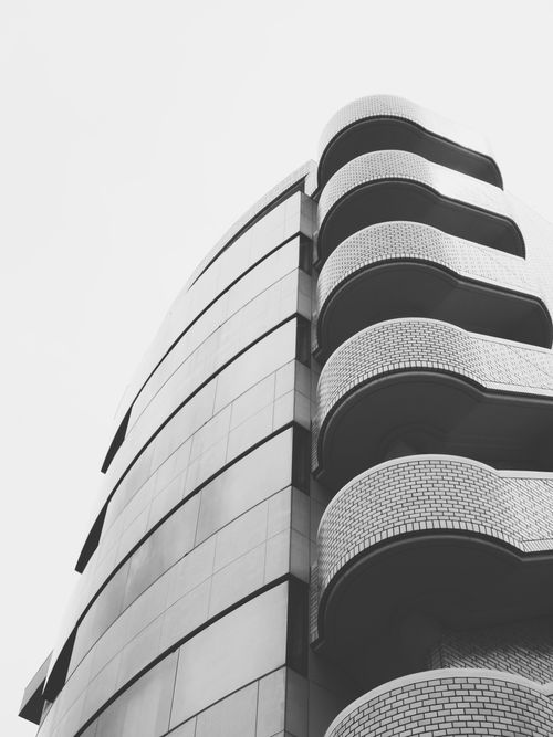 Free Minimalist black and white photo of a modern curved building with geometric patterns. Stock Photo