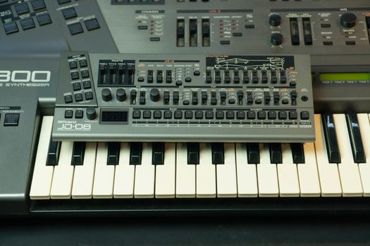 Detailed view of an electronic audio mixer and synthesizer with knobs and switches.