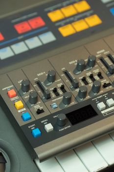 Detailed view of a music production mixer with buttons and dials for sound engineering.
