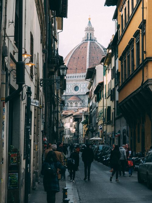 Free A bustling street in Florence with a view of Santa Maria del Fiore's iconic dome. Stock Photo