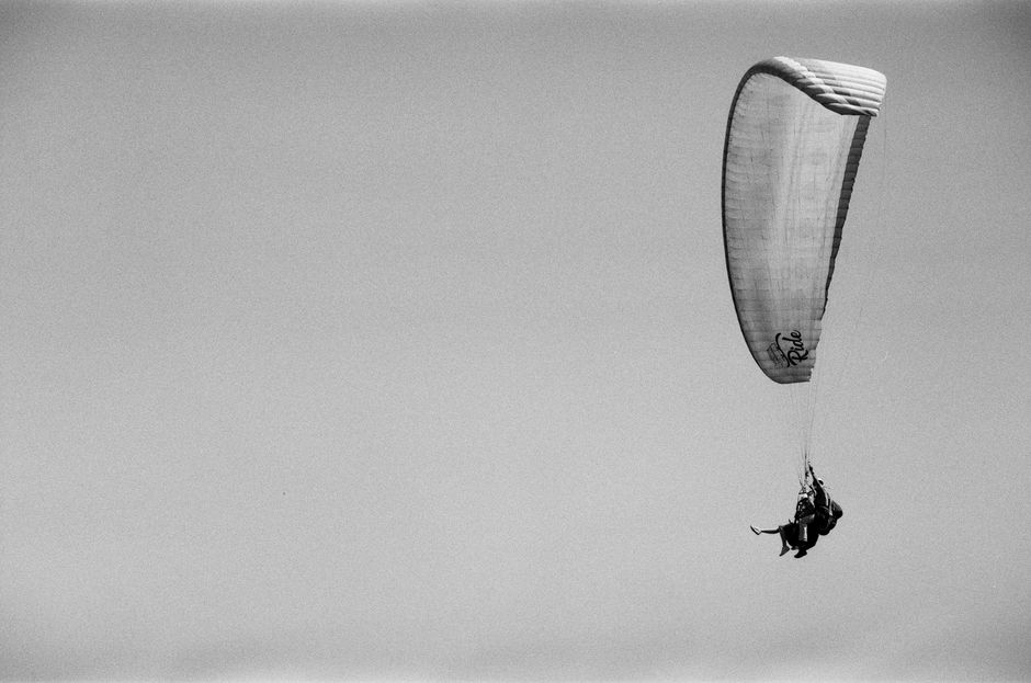 Exciting black and white aerial view of paragliding in South Africa, showcasing the thrill of flight.