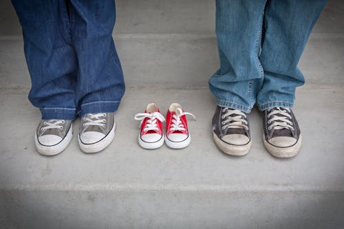 Person in Blue Denim Pants Wearing Gray and White Low Tops