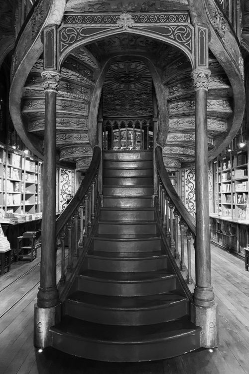 Free Explore the classic wooden spiral staircase inside a vintage Portuguese library. Stock Photo