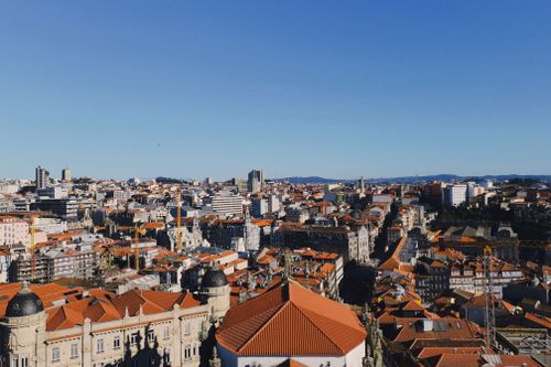 Free A breathtaking aerial view of Porto, Portugal showcasing vibrant rooftops and a clear blue sky. Stock Photo