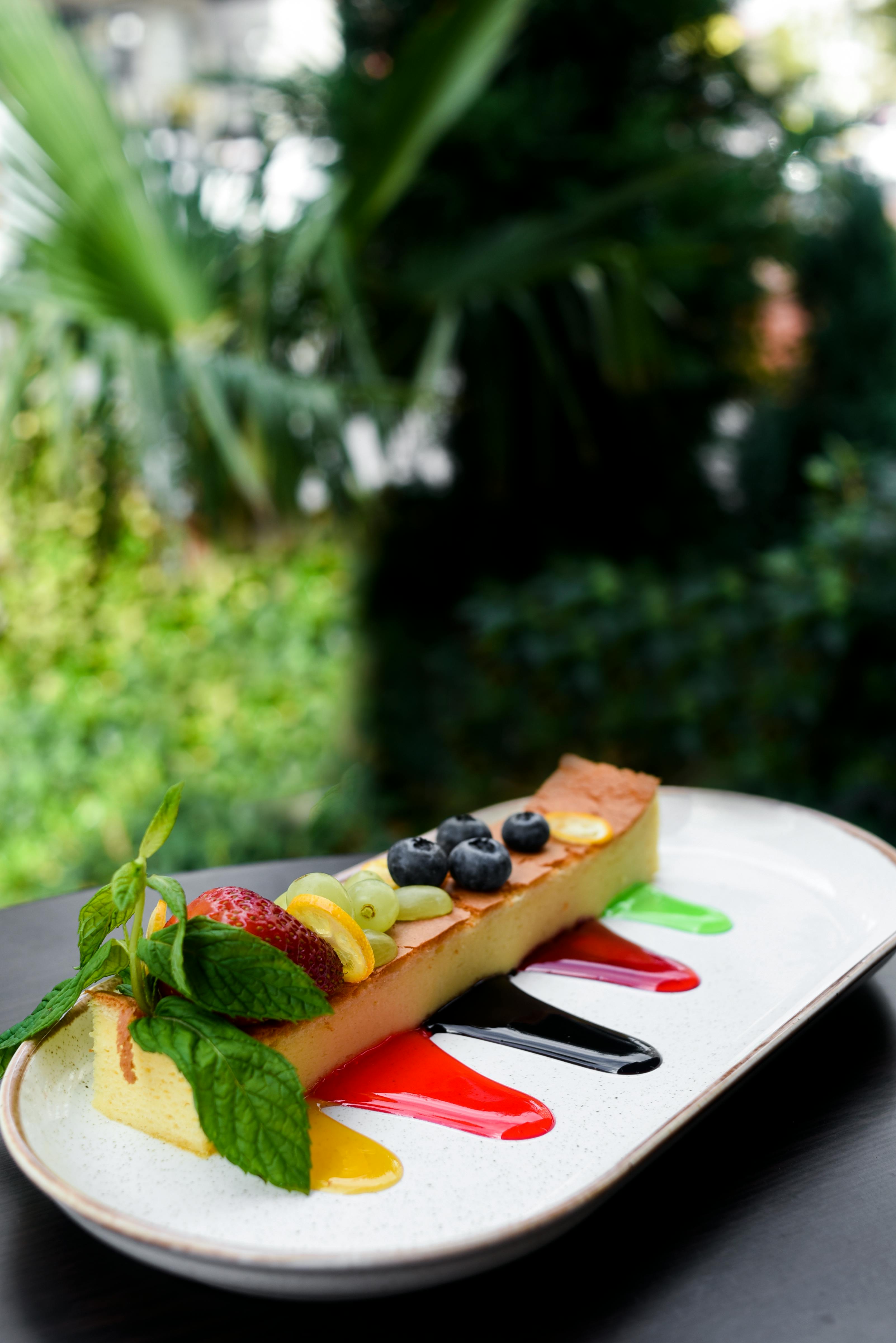 a slice of cake with fruits topping on a long plate