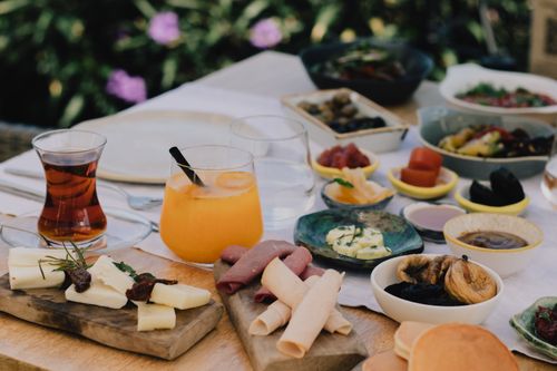 Free A rustic outdoor table setting featuring a diverse antipasto spread with refreshing drinks. Ideal for food lovers. Stock Photo