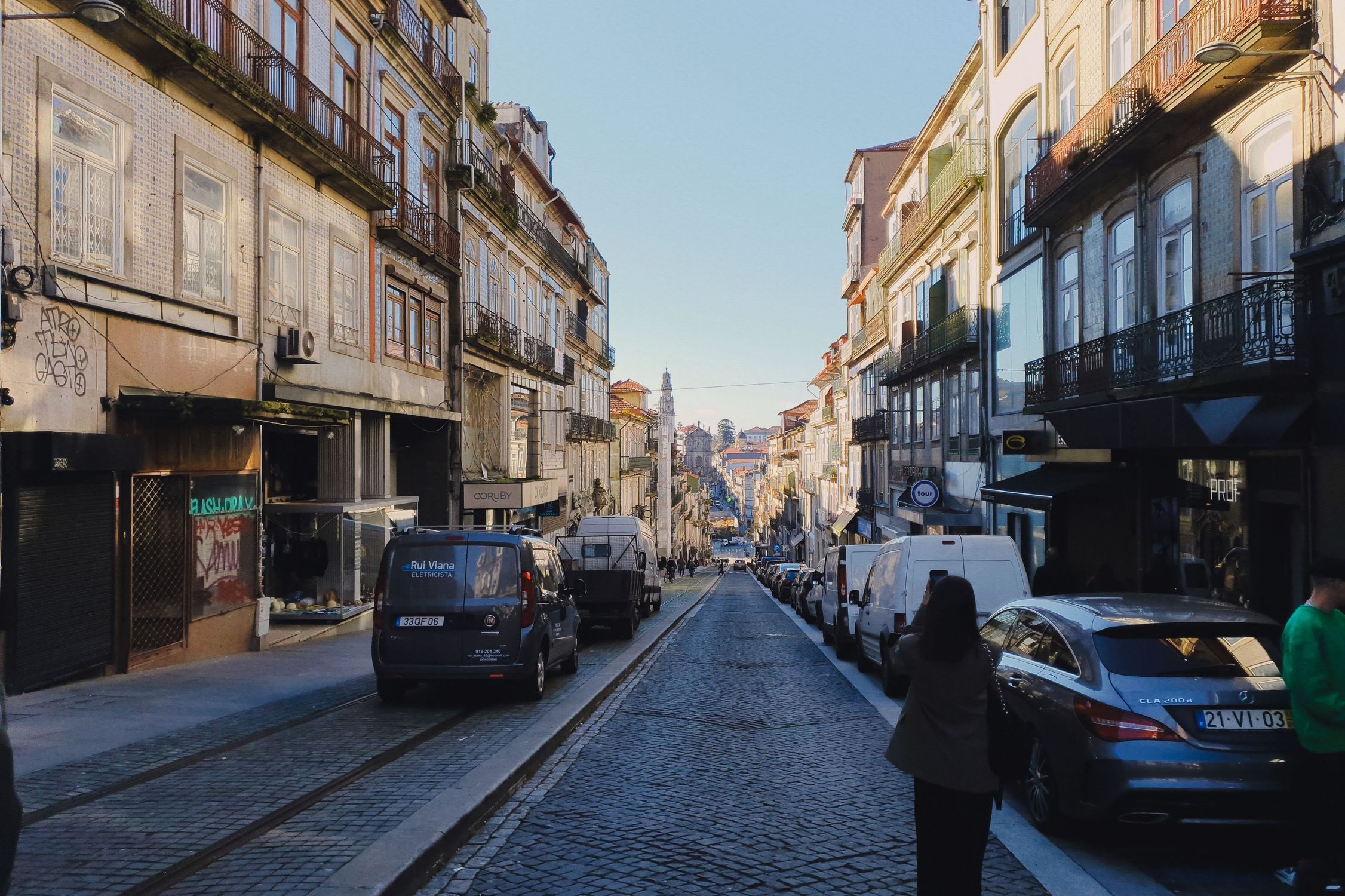 A picturesque street in Porto, Portugal showcases historic architecture and vibrant urban life.