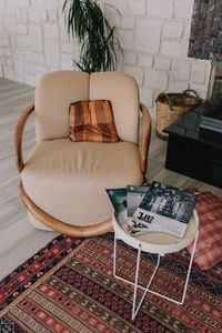 A stylish and cozy living room setup featuring a plush armchair, magazines, and warm decor.