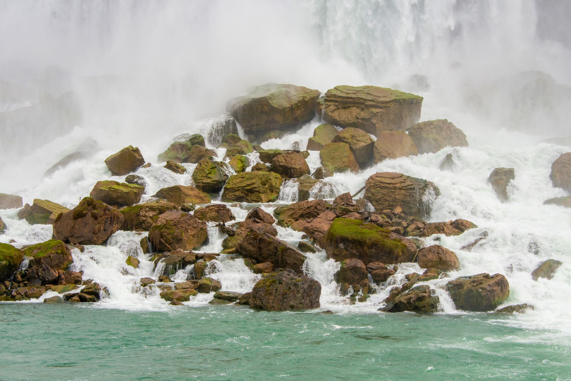 Powerful waterfall cascading over moss-covered rocks at Niagara Falls, USA.