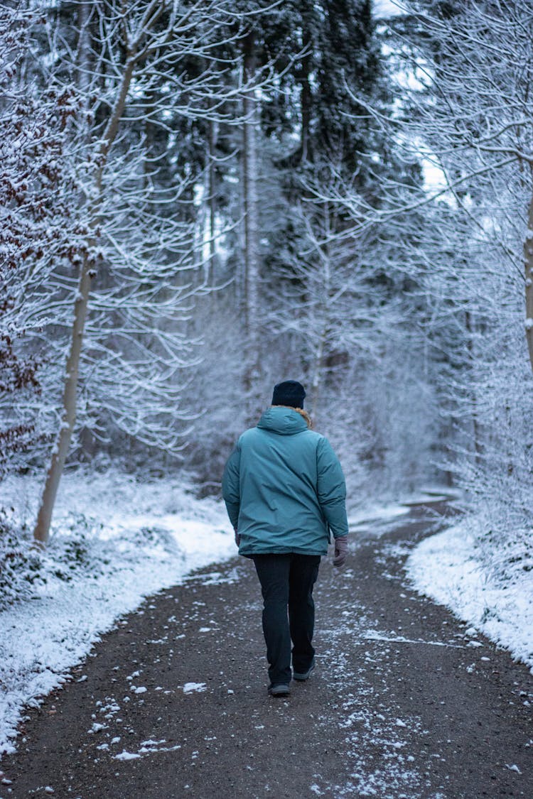 Man Walking Through A Forest In Winter 