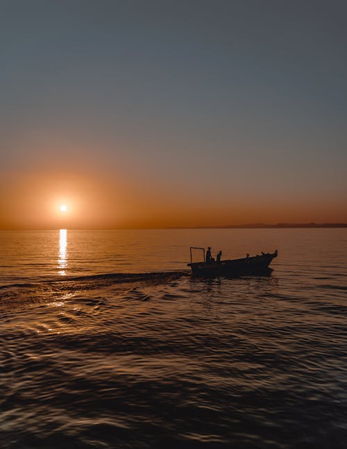 Silhouette of People Riding a Boat during Sunset