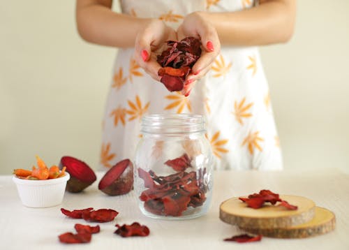 Free Hands of a Woman Holding Dried Beetroot Chips Stock Photo