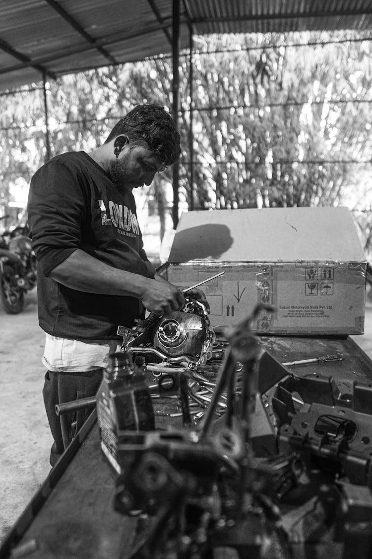 Man In Black T-shirt Fixing Parts Of A Vehicle