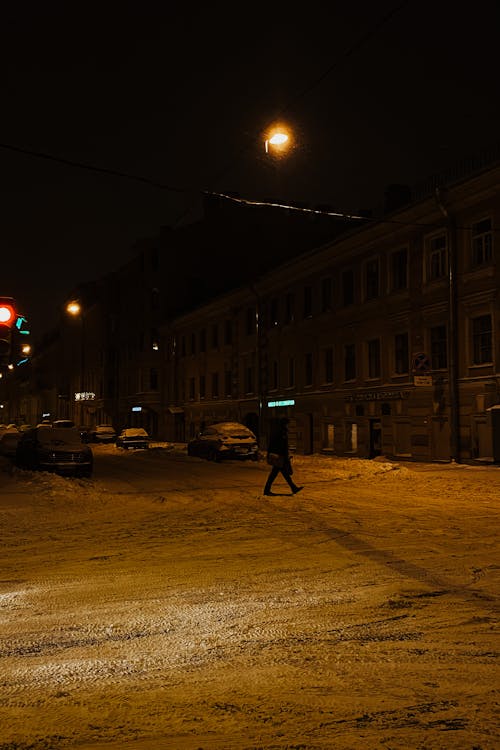 A Person Crossing a Snow Covered Street