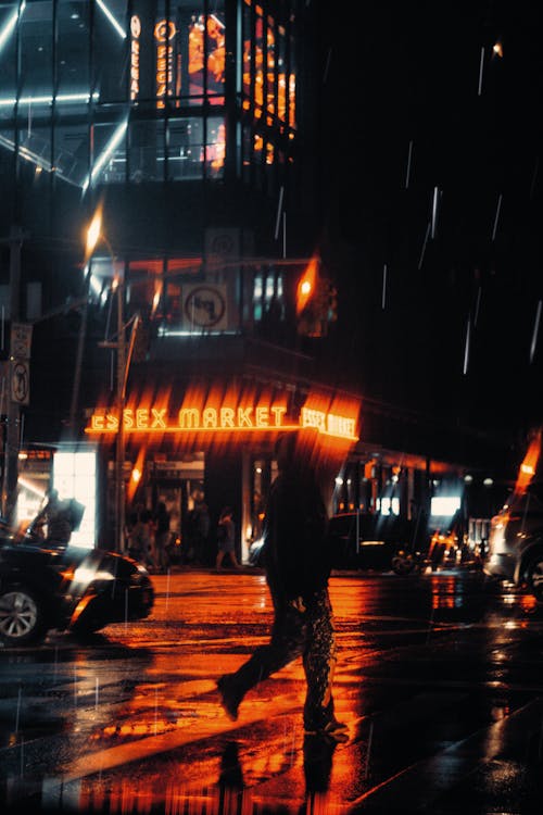 Man in Black Jacket Walking on Street during Night Time