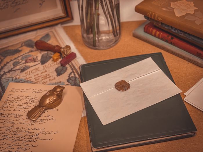 A wax-sealed handwritten letter resting on a wooden desk
