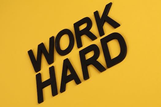 Black text 'Work Hard' on a vibrant yellow background for motivation.