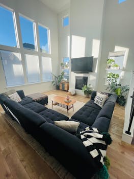 A spacious, high-ceiling living room with contemporary furniture and natural light.