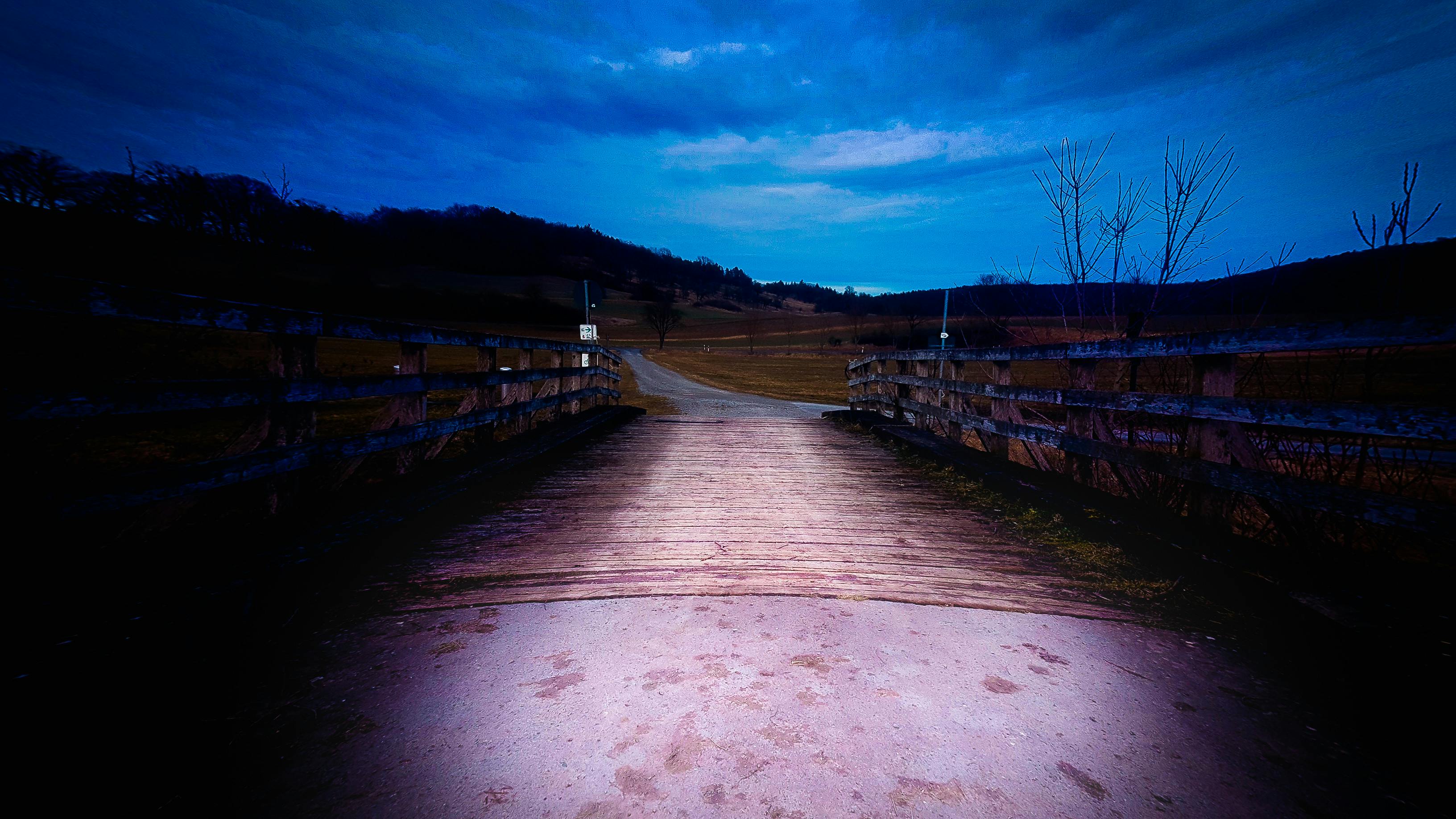 在德国巴德科尔伯格-赫尔德堡戏剧性的暮光天空下，有一座木桥