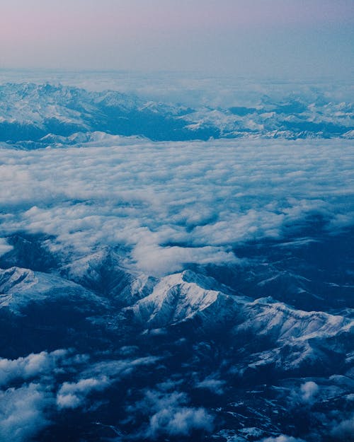 Aerial View of Clouds Over Snow Covered Mountains