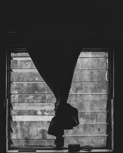 Free A moody black and white image of a window with curtains and jalousies. Stock Photo