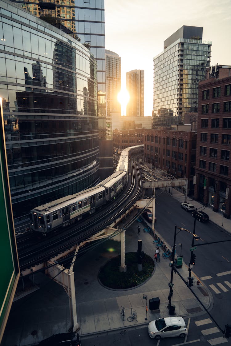 Urban Street With Train Tracks Above Ground At Sunset