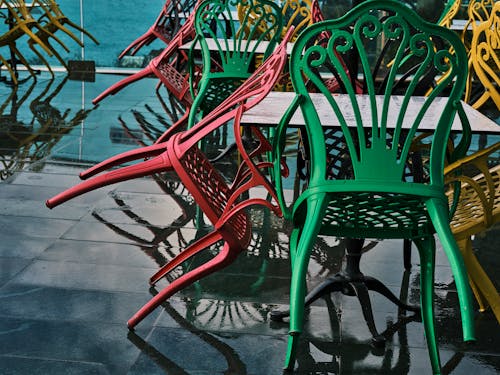 Colorful Metal Chairs on a Wet Wooden Floor