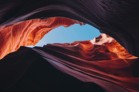 Spectacular view of Antelope Canyon's vibrant rock formations under a clear blue sky.