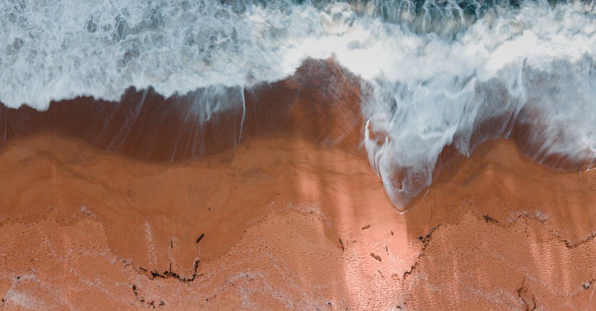 Sand Rushing Waves Rushing on Brown Sand · Free Stock Photo