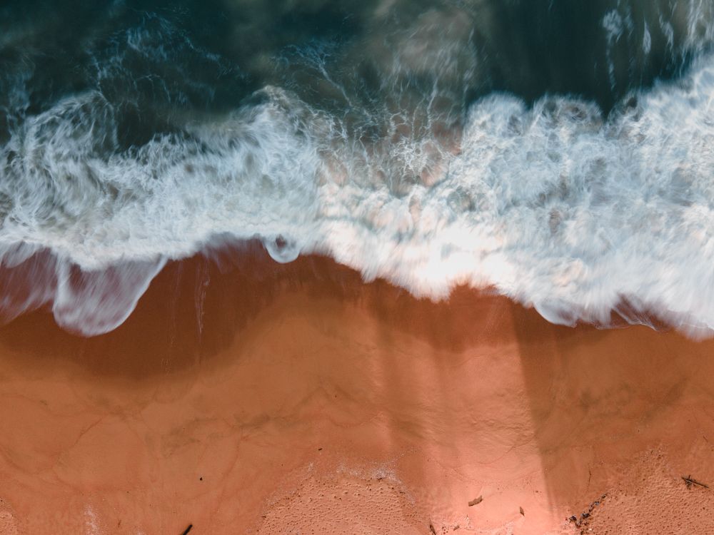 Sand Rushing Sea Waves Rushing on Brown Sand · Free Stock Photo