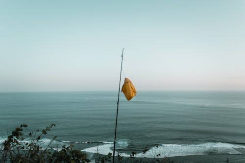 Yellow Flag on Pole by Ocean