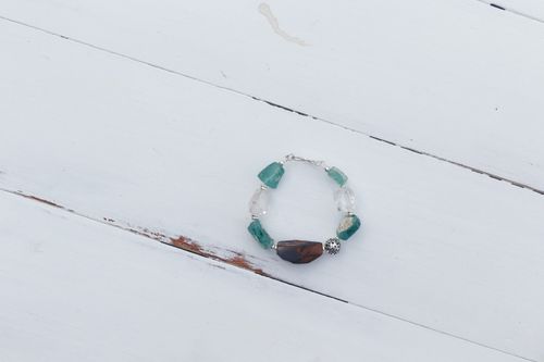 Free Close-up of a handmade gemstone bracelet displayed on a rustic white wooden surface. Stock Photo