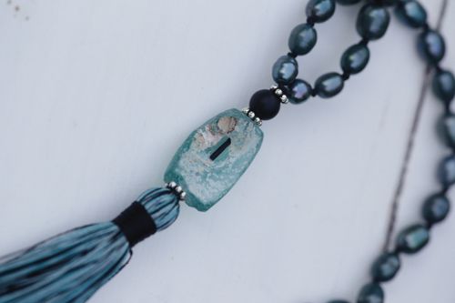 Free Close-up of a stylish beaded necklace featuring a turquoise gem on a white surface. Perfect for jewelry collections. Stock Photo