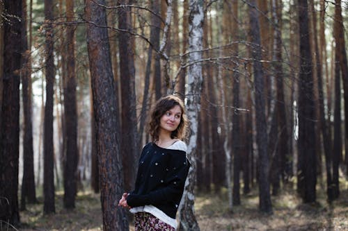 A Woman in Black Long Sleeve Shirt Standing in the Woods