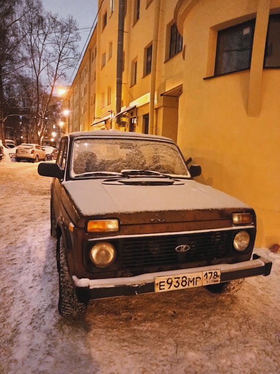 Brown Car beside Yellow Building