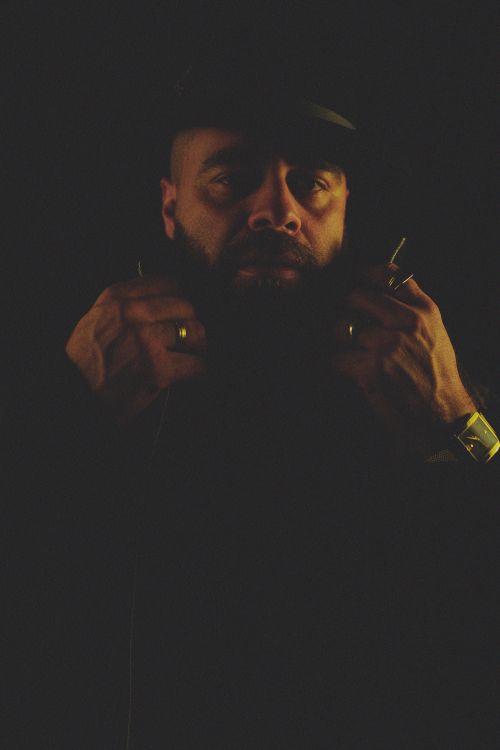 Free Dark and mysterious portrait of a bearded man in a hat against a black background. Stock Photo