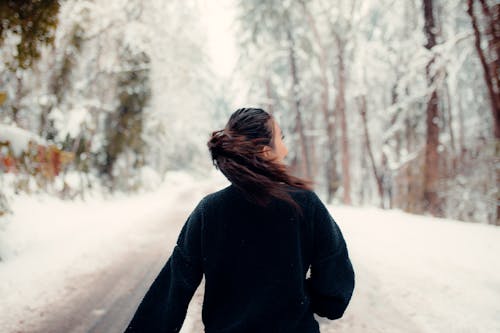 Free A Woman in Black Jacket  Standing on Snow Covered Ground Stock Photo
