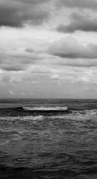 Monochrome seascape capturing the serene and tranquil ocean under a cloudy sky.