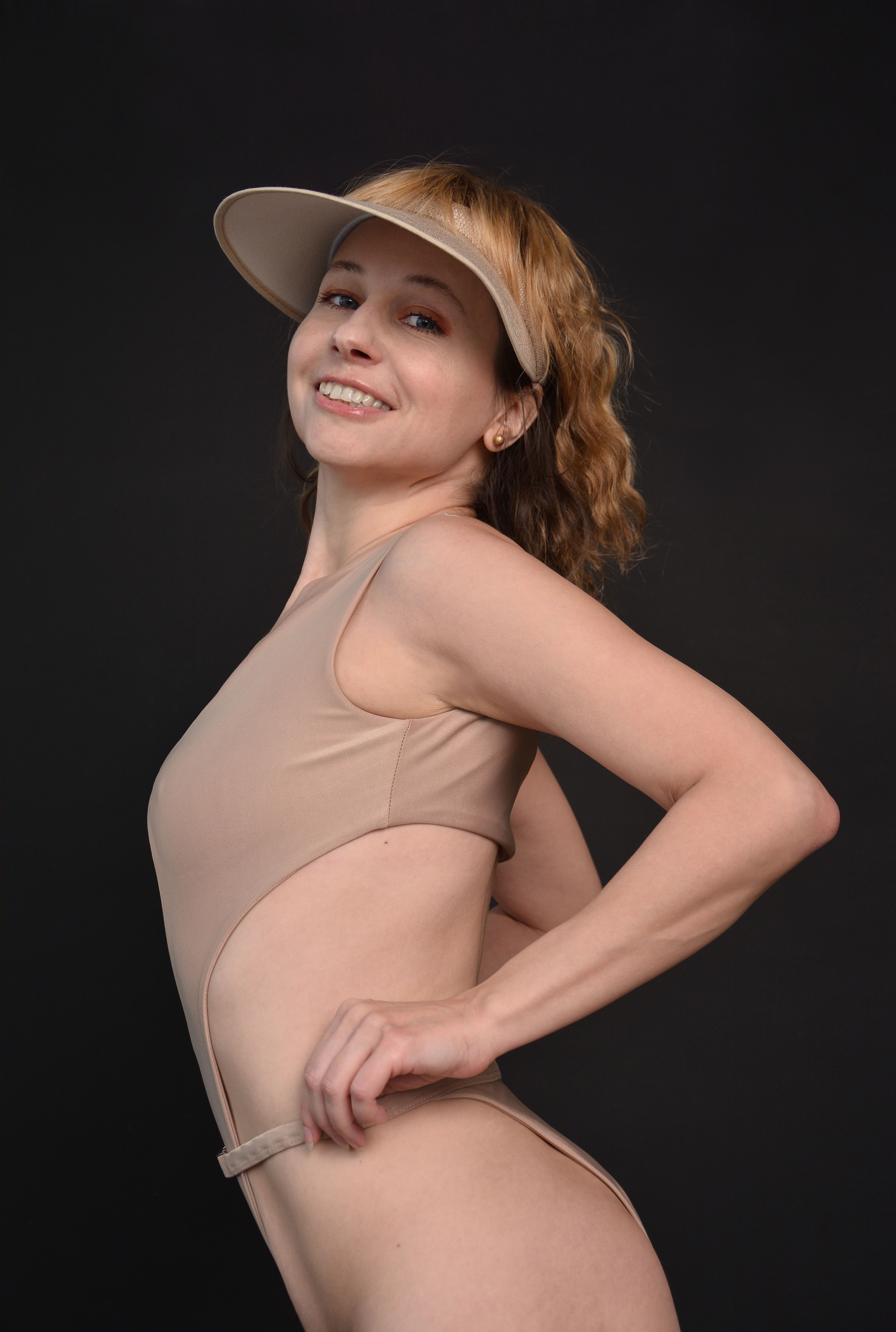 A Woman Modeling in a Swimsuit and a Sun Visor · Free Stock Photo