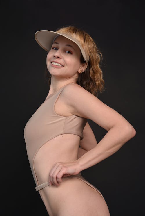A Woman Modeling in a Swimsuit and a Sun Visor