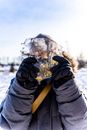 Person in Black Jacket and Brown Backpack Covering Face With Ice