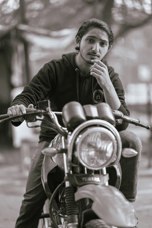 Free man in Hoodie Sweater Sitting on a Motorcycle Stock Photo