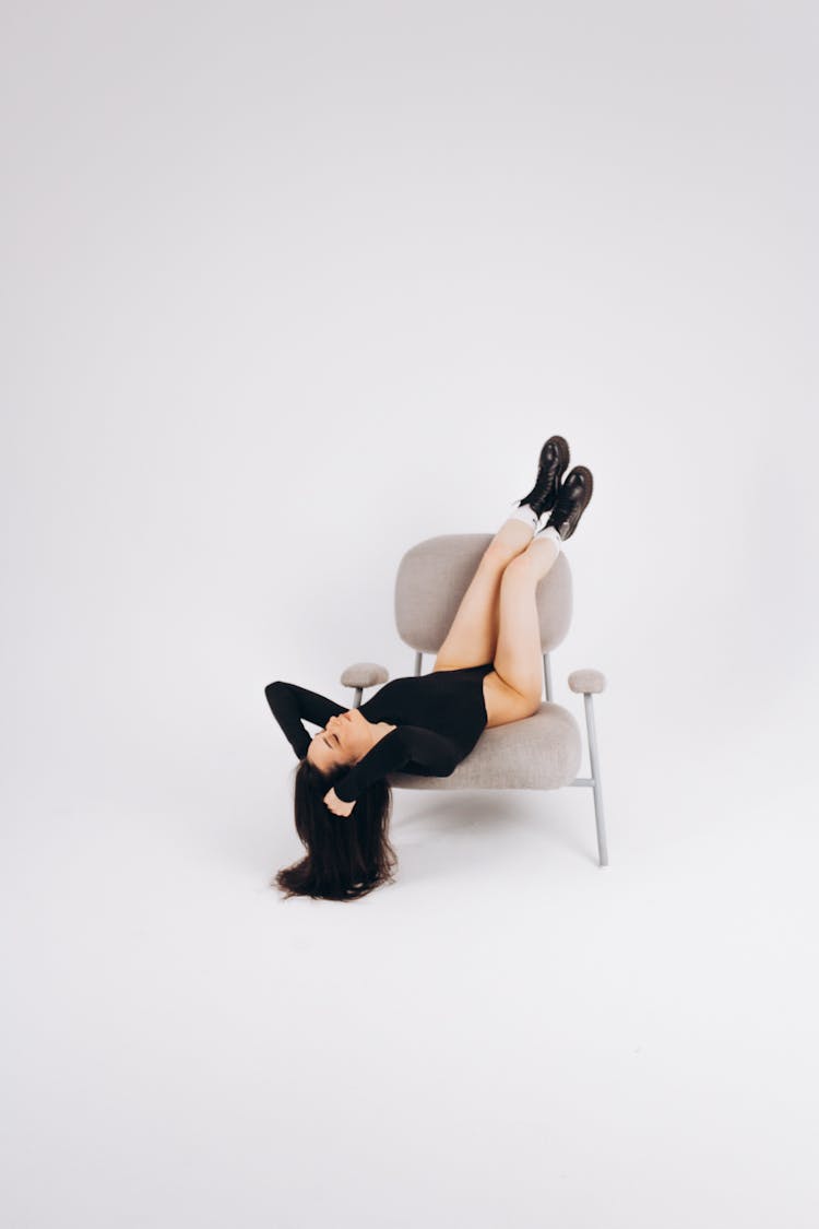 Woman Sitting Upside Down On A Chair