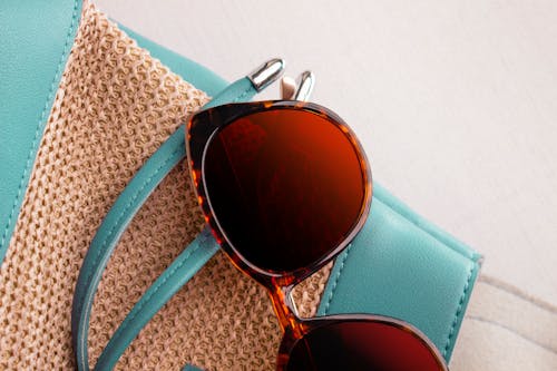 Blue and Brown Sunglasses on Teal Leather Bag