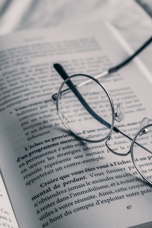 Close Up Photo of Eyeglasses on a Book