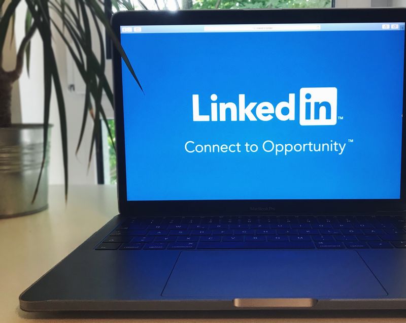 Laptop screen showing the LinkedIn homepage, preparing a LinkedIn post