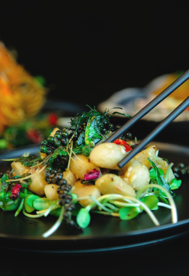 Eating Vegetable Salad With Chop Sticks