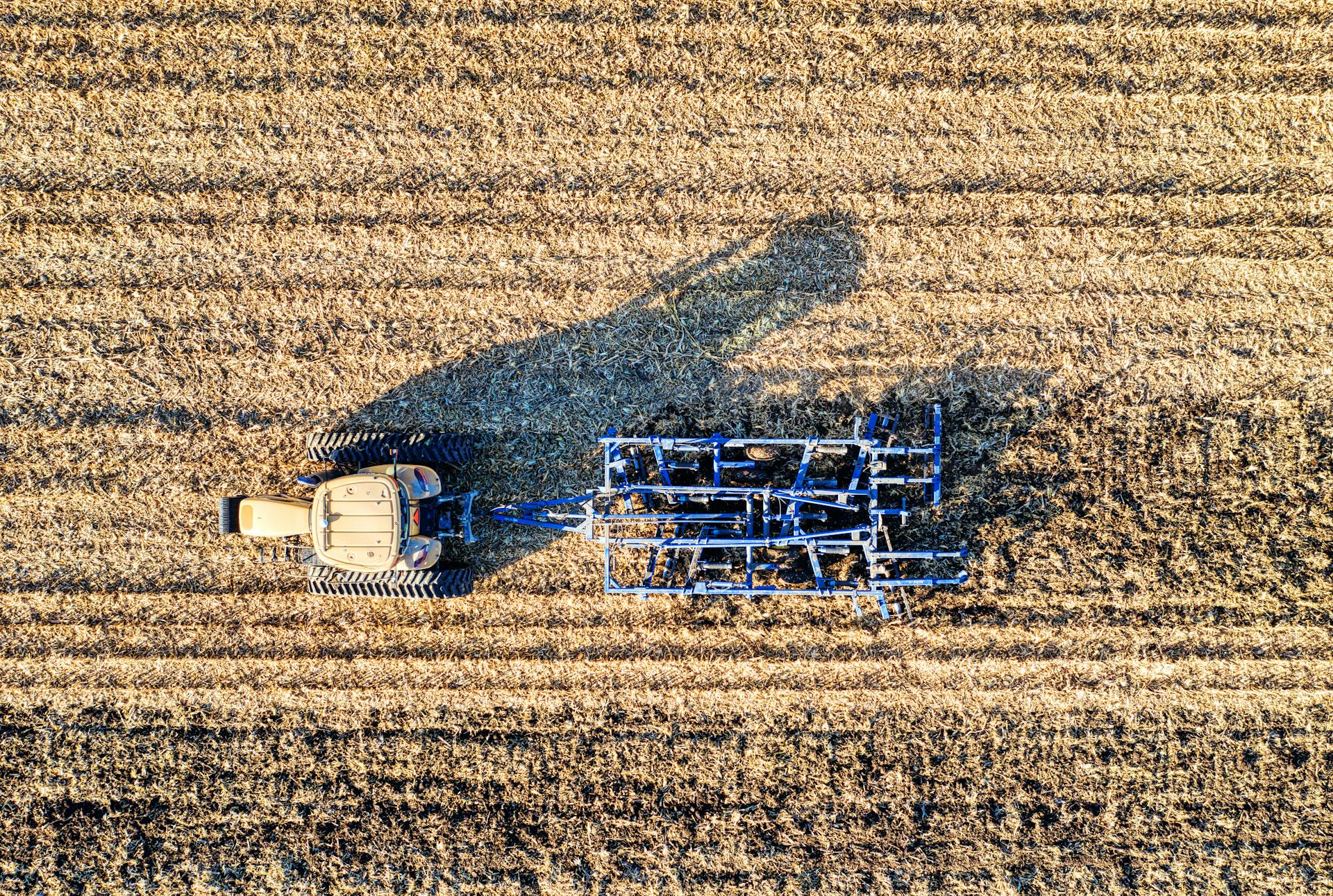 An aerial image of a tractor plowing fields in rural Minnesota, showcasing agricultural patterns.