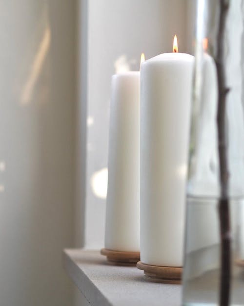 White Lighted Pillar Candles on Table
