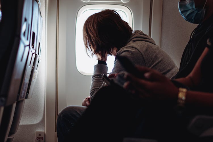 A Person Looking Out Of An Airplane Window